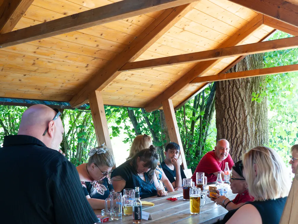 Mehrere Menschen sitzen gemeinsam an einem langen Tisch und essen zusammen